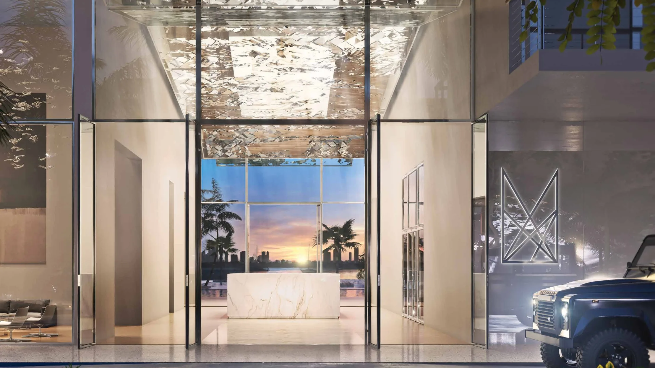 The lobby at dusk beneath its double-height canopy of interlayered reflective panels, framing a view through to the bay