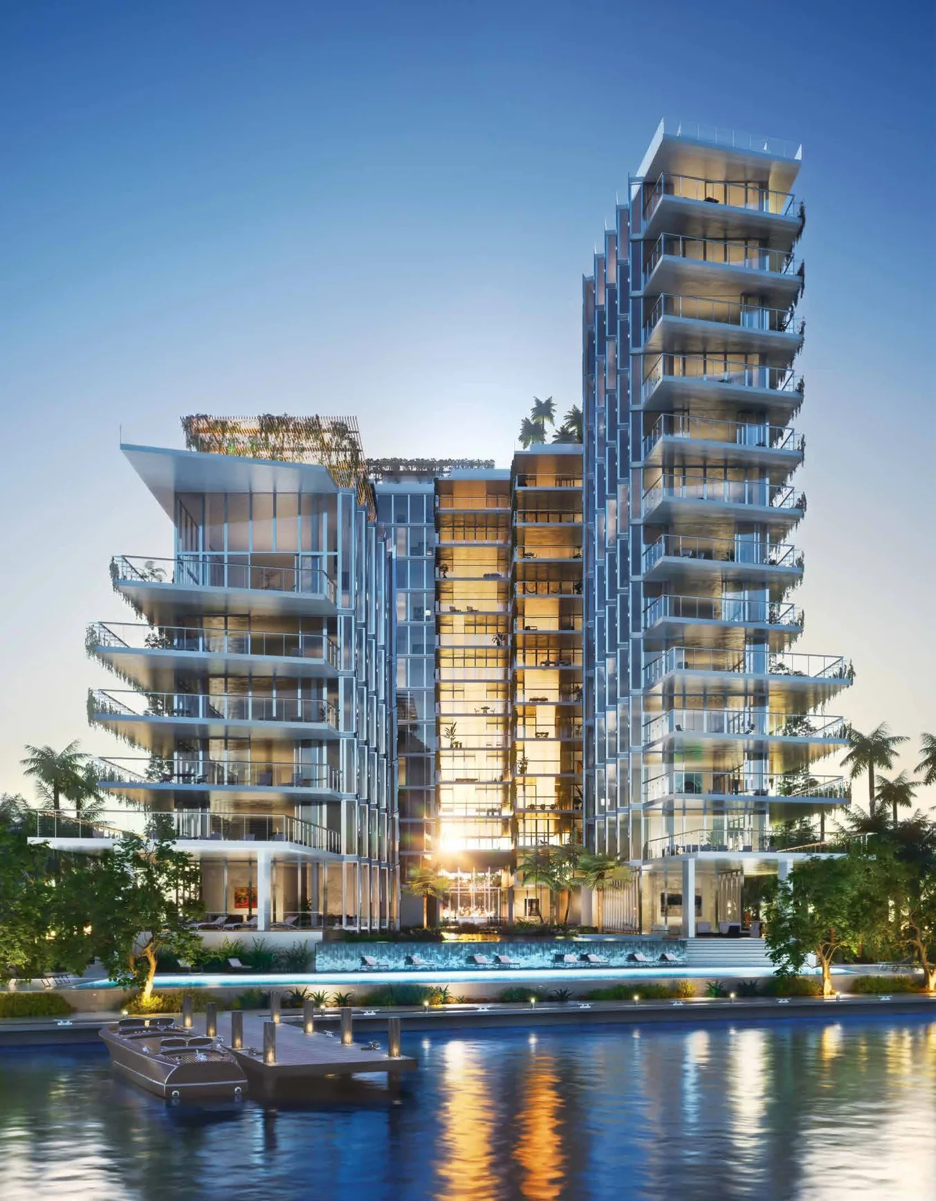 Monad Terrace from the water at dusk, the two towers lit above the pool deck and the dock on Biscayne Bay