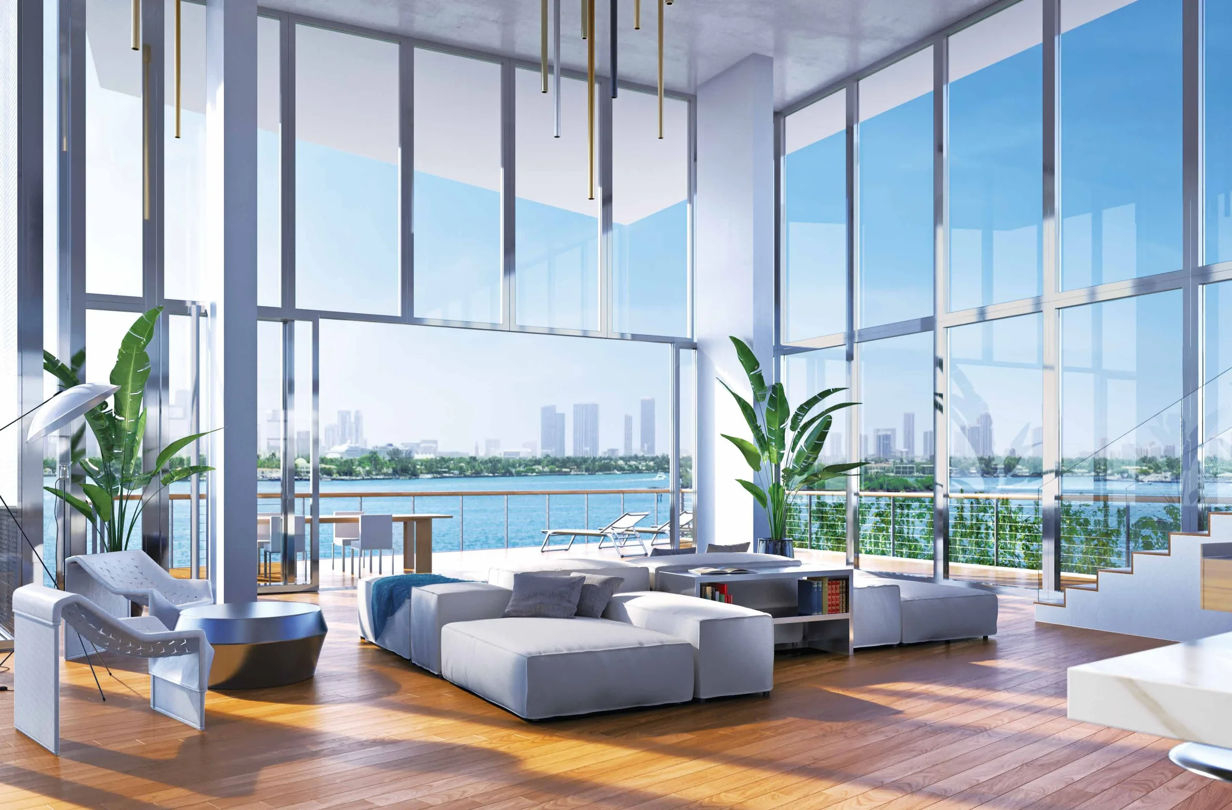 A double-height living room with full-height glass on two sides, an open stair at the right and Biscayne Bay beyond
