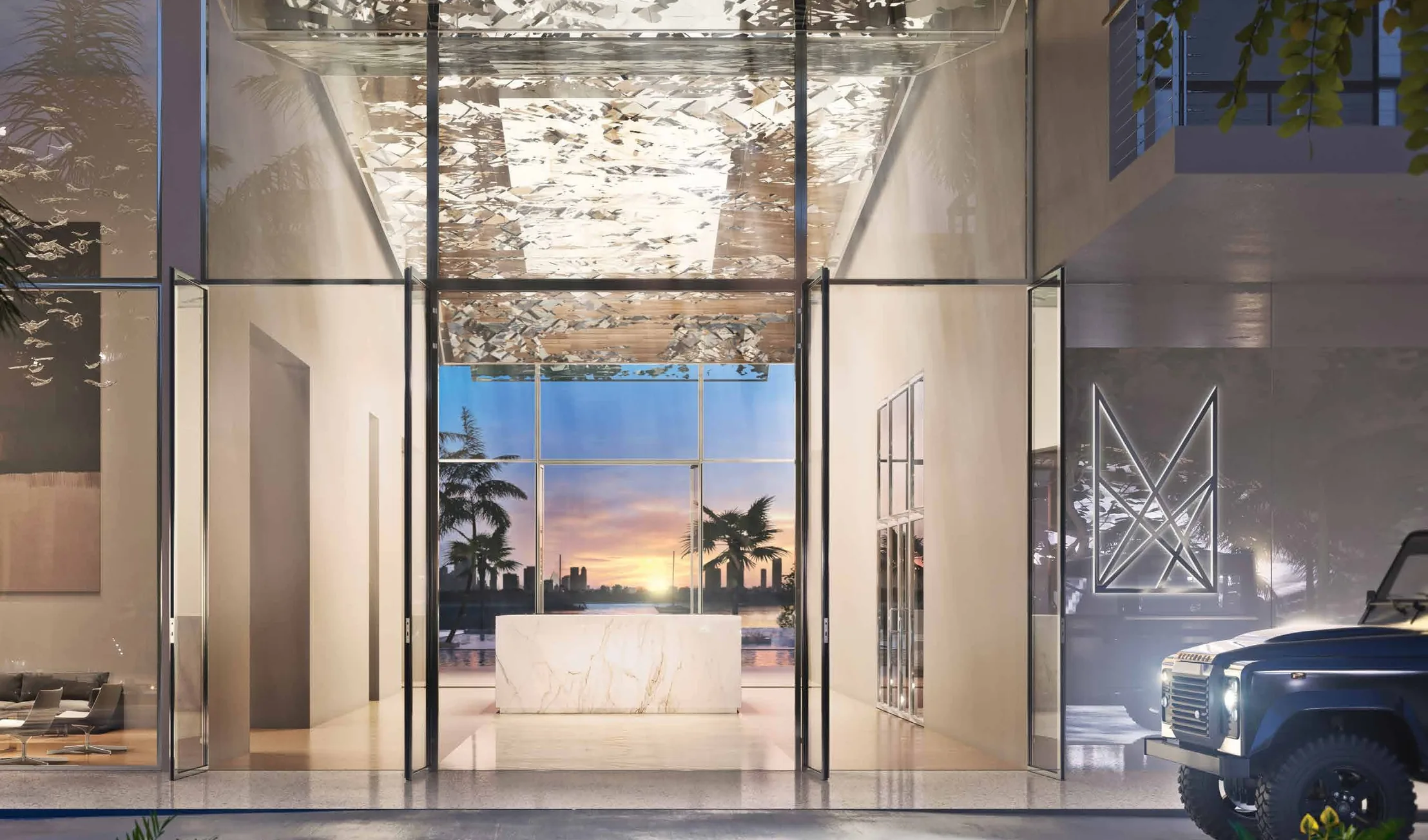 The lobby entrance at dusk under its faceted reflective canopy, framing the bay through the far glass